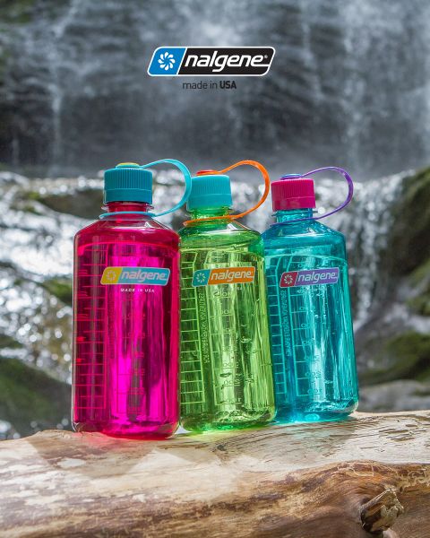 Drei bunte Nalgene-Wasserflaschen (rosa, grün und blau) stehen auf einem Baumstamm vor einem Wasserfall. Jede Flasche hat einen Schraubdeckel und eine Trageschlaufe. Darüber prangt das Nalgene-Logo mit dem Schriftzug „Made in USA“.