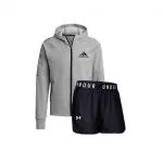 Ein grauer Adidas-Kapuzenpullover mit dem Logo auf der Brust, kombiniert mit schwarzen Under Armour-Shorts mit dem Markennamen auf dem Bund.