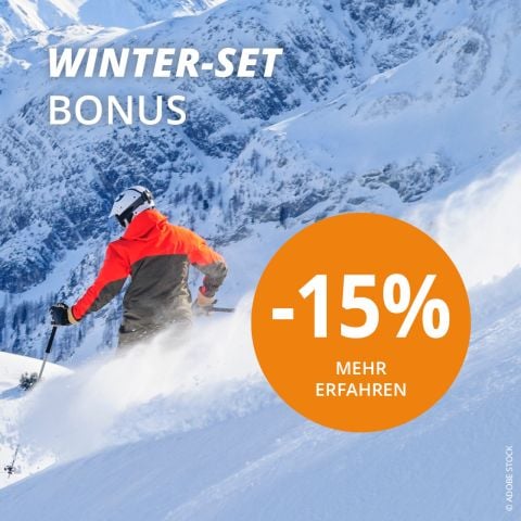 Ein Skifahrer in einer hellen Jacke fährt unter einem klaren blauen Himmel einen verschneiten Berghang hinunter. Der Textüberlagerungstext lautet „WINTER-SET BONUS -15% MEHR ERFAHREN“ und wirbt für ein Rabattangebot. Schneebedeckte Gipfel füllen den Hintergrund.