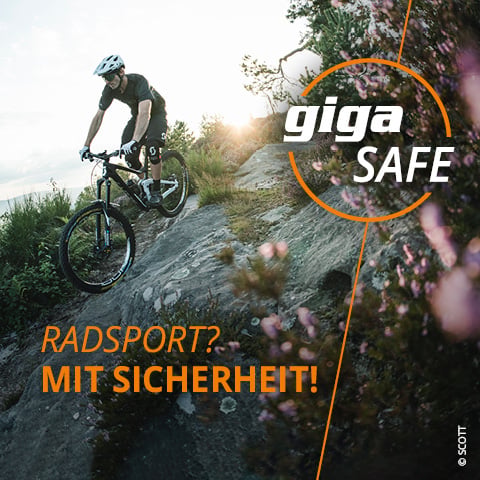 Ein Radfahrer mit Helm fährt bei Sonnenuntergang einen felsigen Abhang hinunter. Der Himmel ist teilweise bewölkt. Der Text lautet „giga SAFE“ und „RADSPORT? MIT SICHERHEIT!“ mit Pflanzen und Blumen im Vordergrund.
