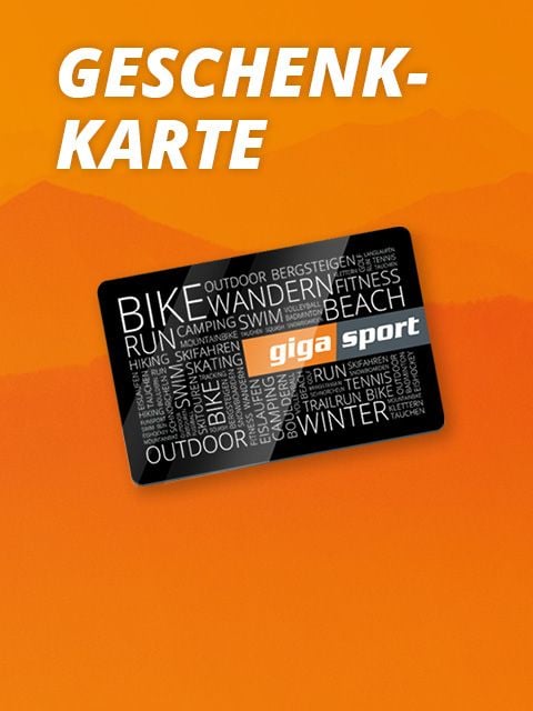Geschenkkarte mit dem Text „GESCHENK-KARTE“ und „giga sport“. Auf der Karte sind Wörter wie „BIKE“, „WANDERN“ und „FITNESS“ in verschiedenen Schriftarten zu finden. Der Hintergrund ist ein orangefarbener Farbverlauf mit stilisierten Bergen.