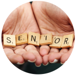 Die Hände halten Scrabble-Steine, die das Wort "SENIOR" ergeben.