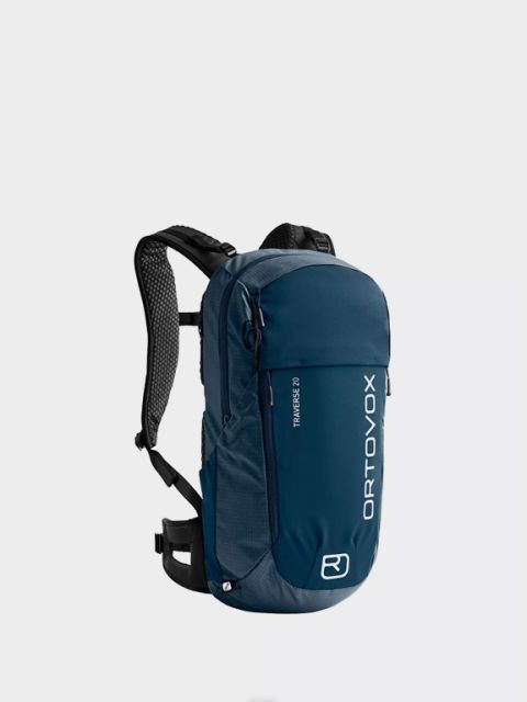 Blauer Ortovox-Rucksack mit dem Schriftzug „Rucksäcke“ darüber. Mit mehreren Reißverschlüssen, verstellbaren Riemen und orangefarbenen Details an Reißverschlussschieber und Clips. Der Markenname ist vertikal in Weiß aufgedruckt.