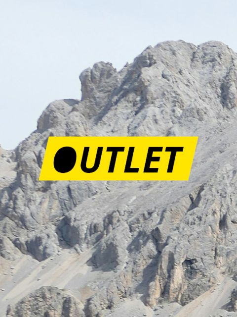 Das Wort „OUTLET“ in schwarzer Schrift auf einem gelben rechteckigen Hintergrund, überlagert von einem felsigen Berggipfel.