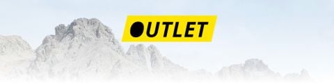 Das Wort „OUTLET“ in schwarzer Schrift auf einem gelben rechteckigen Hintergrund, vor dem sich schneebedeckte Berggipfel abzeichnen.